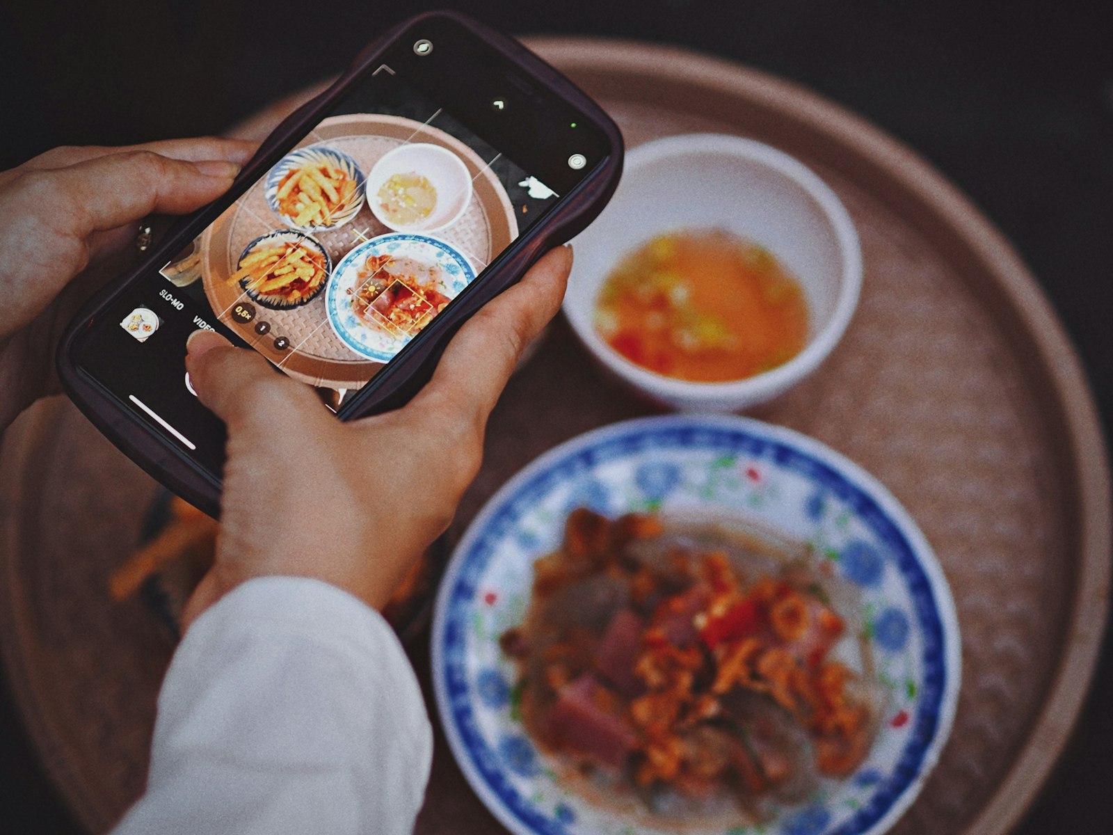 料理をスマートフォンで撮影している手元